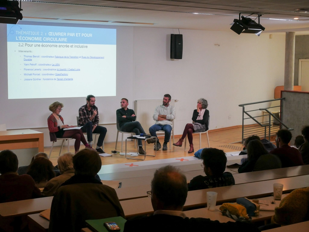 Photo table ronde - Participants sur la scène, spectateurs dans un auditorium