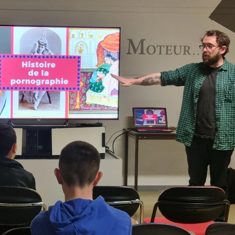 Photo prise de la salle, l'intervenant devant un écran.