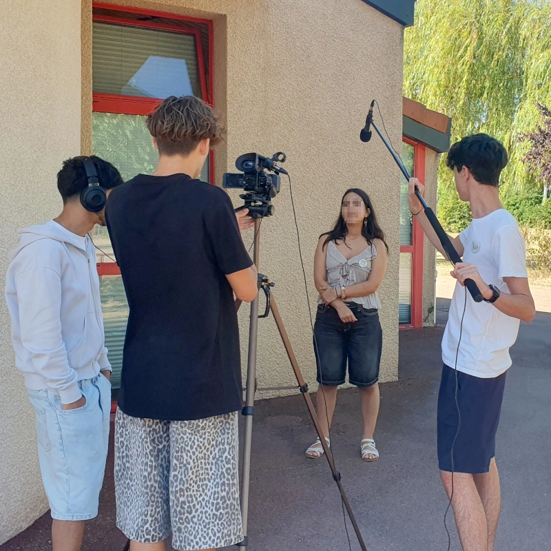 Groupe de 4 jeunes enregistrant une vidéo en extérieur